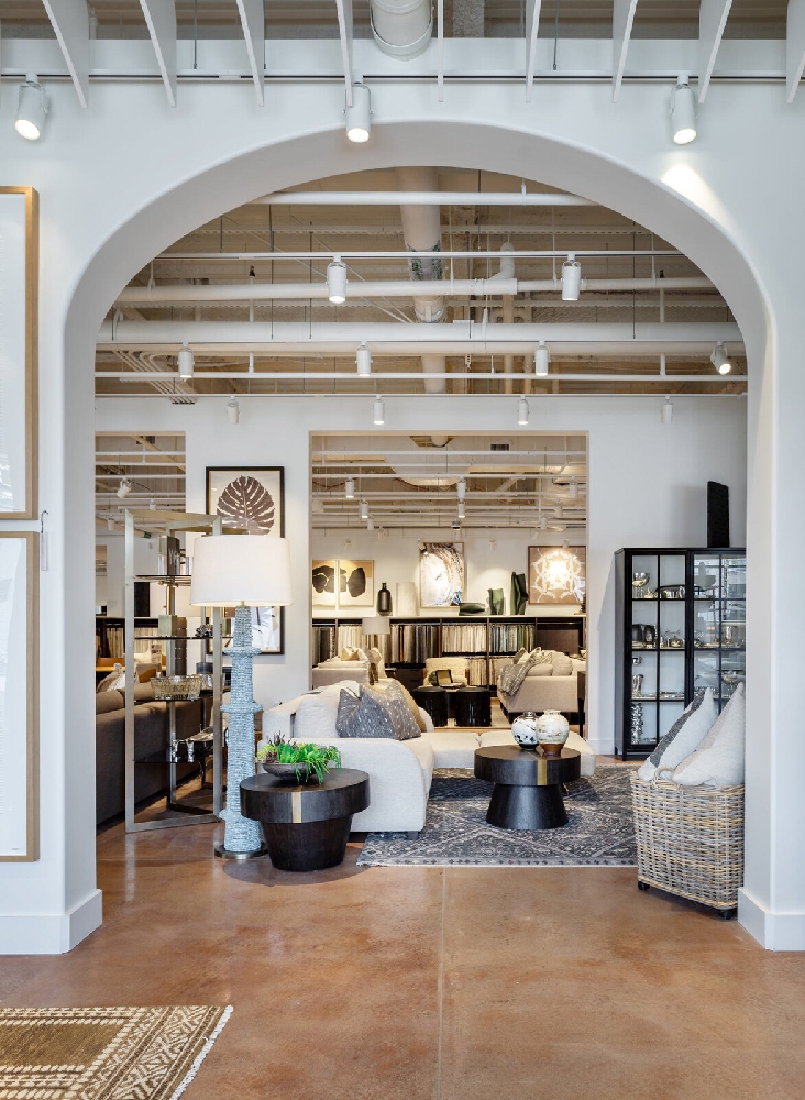 HW Home 9+CO Denver showroom viewed through a large architectural arch with custom upholstery displays