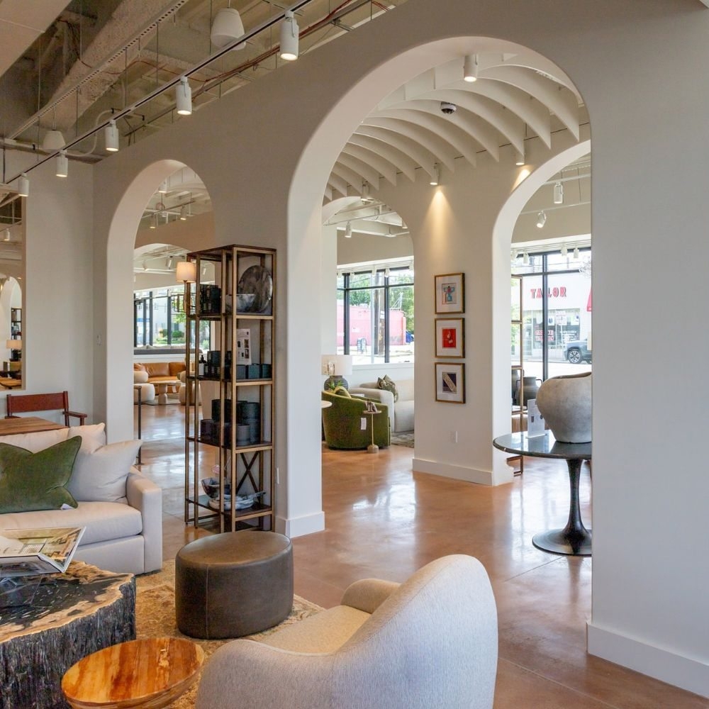 Furniture and lighting displayed beneath broad white arches in a showroom